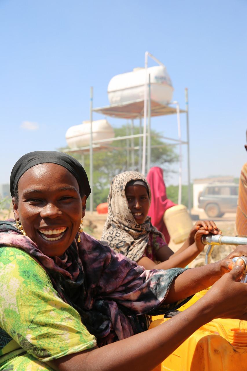 ソマリア　日本の浄水技術が生かされたIOMの給水施設により 清潔な水を利用できて笑顔を浮かべるソマリア避難民 © IOM 2014 (photo: Koji Kumamaru)