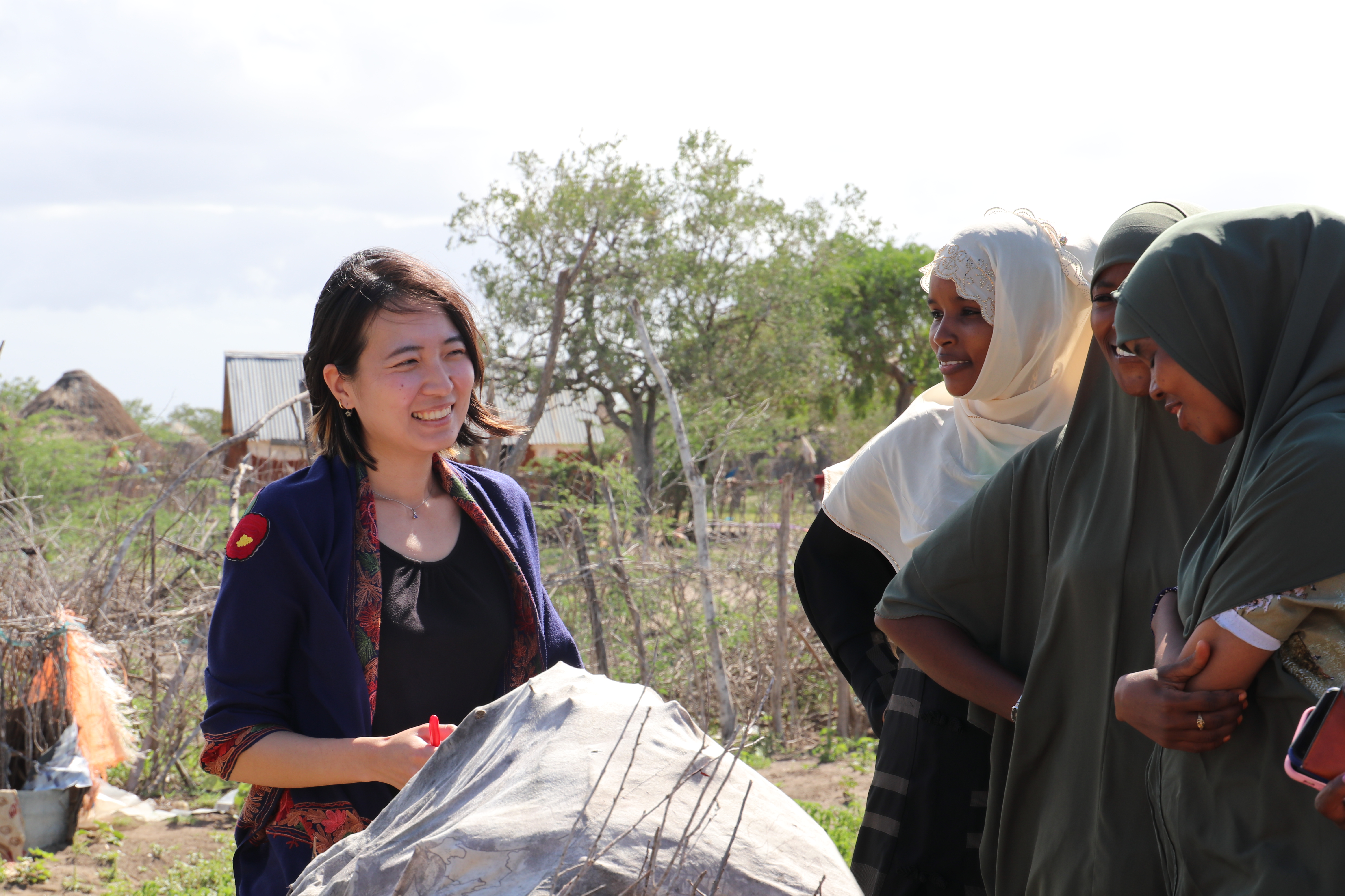 Tana Riverにて生計支援を受けた遊牧民女性とフィールド視察を行う（写真：IOMナイロビ事務所提供）